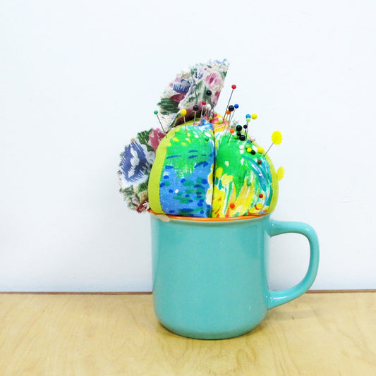 Un cactus en tissu dans une tasse avec des épingles